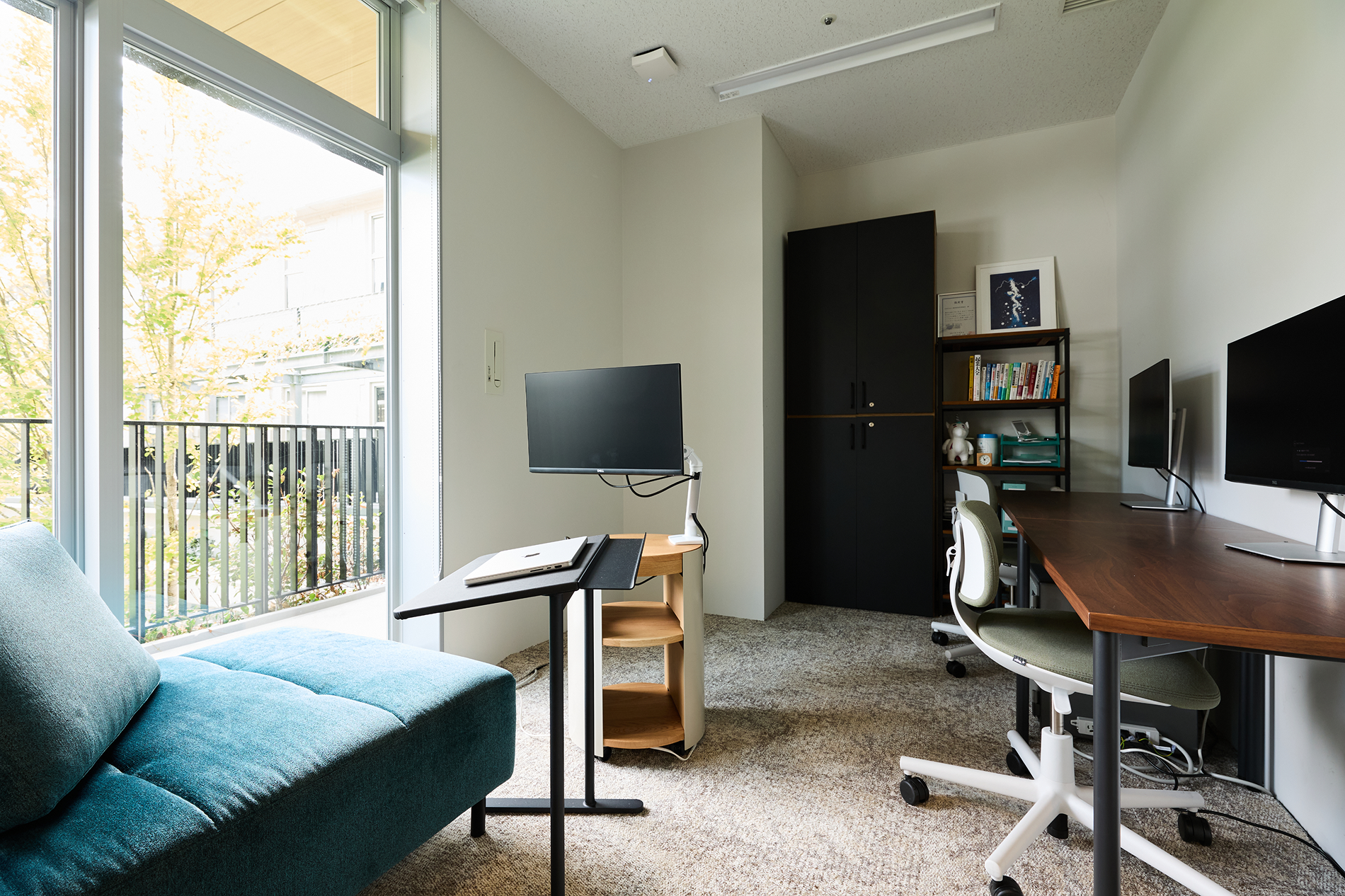 窓際のソファとデスクを備えた落ち着いたオフィス空間